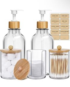 three glass containers with wooden lids and toothbrushes in front of each other on a white background