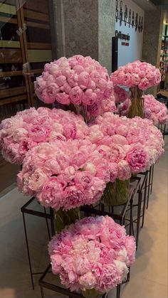 pink carnations are arranged in vases on display at the store's entrance