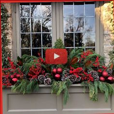 a window box filled with christmas decorations and greenery