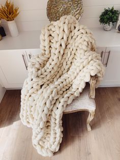 a large chunky blanket sitting on top of a chair