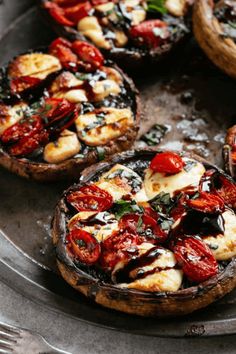 baked mushrooms with tomatoes and mozzarella sauce on a metal platter, ready to be eaten