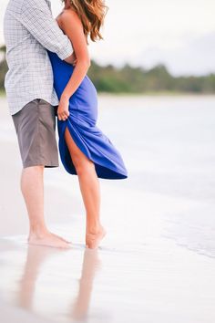 a man and woman kissing on the beach