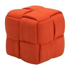 an orange cube ottoman sitting on top of a white floor