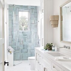 a white bathroom with blue tiles on the walls