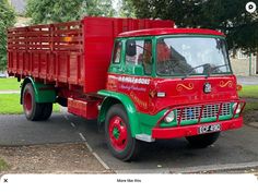 an old red and green truck parked on the street