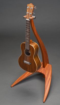 a wooden guitar stand with an acoustic instrument on it