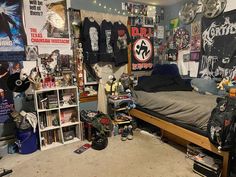 a room filled with lots of clutter and posters on the wall, including a bed