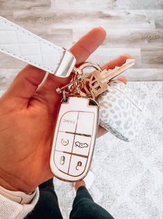 a person holding a keychain with two keys attached to it's sides