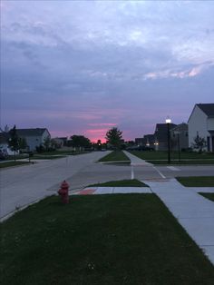 a red fire hydrant sitting on the side of a road next to a street