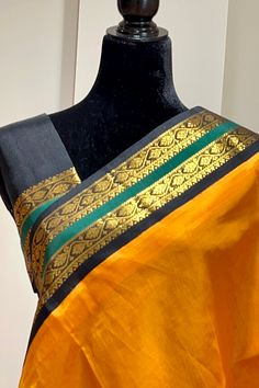 This regal korvai silk cotton saree in mustard yellow with black border and pallu is handwoven. The saree borders are adorned with traditional motifs in gold zari. The black pallu is grand with a rich gold zari work. Approximate Length 6.5 mtrs (inclusive of blouse length) Approximate weight - 1.2 lbs Approximate Height - 48 - 50" Saree comes with fall, picot and tassels done when applicable. Blouse piece is cut. Kindly Note : The colors you see on your device may vary due to the color reproduct Black Silk Saree With Border, Bollywood Style Black Saree With Border, Yellow Banarasi Silk Traditional Wear With Border Detail, Black Saree With Border For Festivals, Festive Yellow Traditional Wear With Border, Yellow Katan Silk Dupatta With Border, Yellow Katan Silk Saree With Border, Yellow Tussar Silk Dupatta With Border, Yellow Banarasi Silk Saree With Border