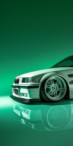 a white car parked on top of a shiny floor next to a green wall in the background