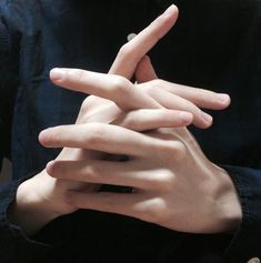 a person with their hands in the shape of a v on their chest and fingers crossed