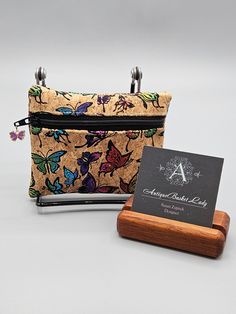 a small purse sitting on top of a wooden stand next to a business card holder