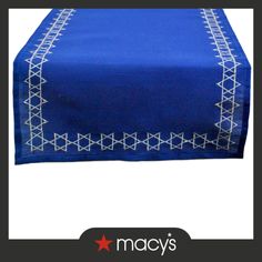 a blue table cloth with white stitching on the edges and an embroidered border around it