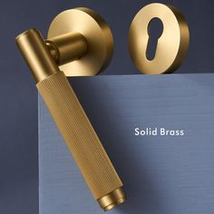 a golden door handle on top of a blue sheet with the word solid brass written below it