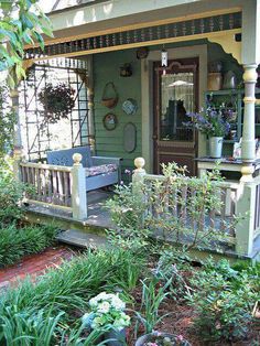 the front porch is covered with plants and flowers