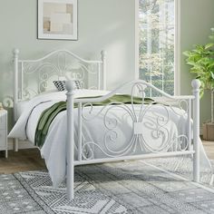 a white bed sitting in a bedroom next to a dresser and window on top of a rug