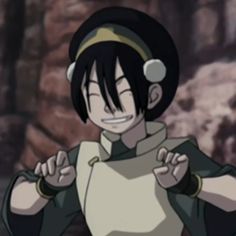 an anime character with black hair and green eyes pointing to the side while standing in front of a stone wall