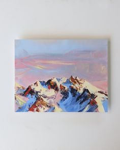 a painting on a white wall with mountains in the background and blue sky above it