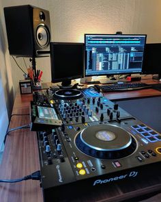 a dj's desk with two computer monitors and sound equipment