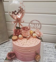 a pink cake with flowers and balloons on top is displayed in an instagramr