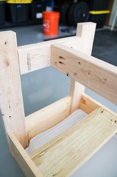 a wooden bench being built in a garage with the seat up and one leg down