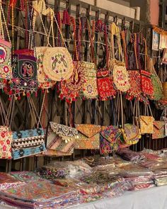 many bags and purses are hanging on the wall