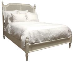 a bed with white sheets and pillows on it