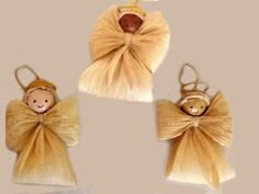 three little angel ornaments are hanging on the wall, one with a teddy bear in it's head