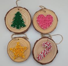 four wooden ornaments with string on them are hanging from twine and decorated with candy canes