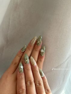 a woman's hands with gold and silver nail polishes on their fingers, holding onto her belly