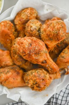 a white bowl filled with fried meatballs next to a cup of sauce