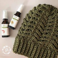 a knitted hat next to two bottles of essential oils