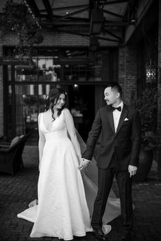 a bride and groom holding hands in black and white