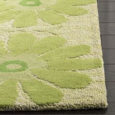 an area rug with green and white flowers on it