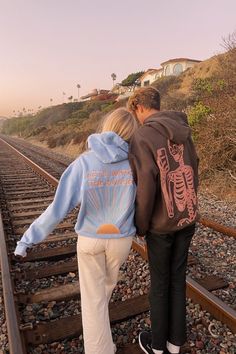 A girl leaning on a boy wearing Dandy Worldwide sweatshirts on the train tracks at the beach for sunset Couples Hoodies Aesthetic, Dandy Worldwide, Many More To Come, Hoodies Aesthetic, Downtown Outfits, Hoodie Aesthetic, Dear Future Husband, Couples Hoodies