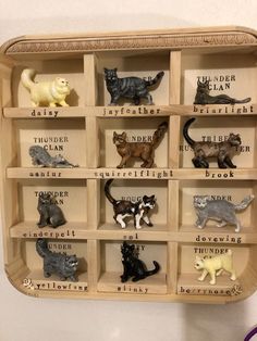 a wooden shelf filled with lots of different types of cat figurines on top of it