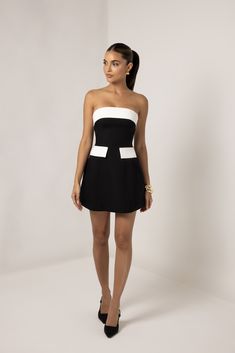 Introducing the Black and White Strapless A-Line Pocket Mini Dress, a sophisticated blend of classic style and modern detailing. Cut from a couture crepe fabric we sourced from the Fashion Week Runway, this dress offers a monochromatic look that can take you from day to night, for any season. This stunning dress features a sleek strapless design with a striking contrast between the black body and white trim, accentuating the neckline and waist. The structured A-line silhouette flatters the figure by cinching the waist and flaring out into a playful mini skirt. The addition of chic front pockets adds both style and practicality, making this dress as functional as it is fashionable. Perfect for any event, this dress combines timeless elegance with a fresh, contemporary twist. Heiress Beverly Hills, Corset Pants, Fashion Week Runway, Black Body, Crepe Fabric, White Trim, Blazer Dress, Stunning Dresses, Xl Dress