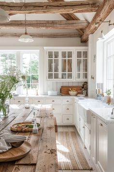 a wooden table sitting in the middle of a kitchen next to a sink and oven