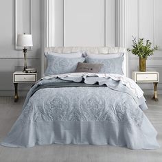 a white bed with blue comforter and pillows