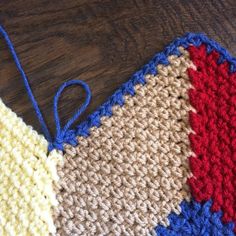 two crocheted pieces of cloth sitting on top of a wooden table