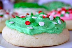 cookies decorated with green frosting and candy canes on a white plate, ready to be eaten