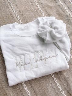 a white t - shirt with the word happy written in cursive writing on it