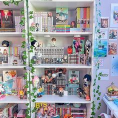 a book shelf filled with lots of books next to a wall covered in pictures and ivy