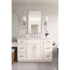 a white bathroom with two sinks and a large mirror over it's vanity area