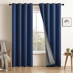 a living room with blue curtains and a chair