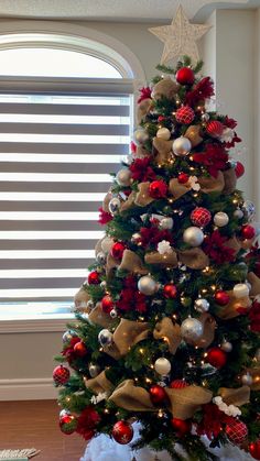 a christmas tree decorated with red, gold and silver ornaments