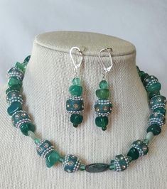 ladies Persian green beaded necklace created with silver embedded , bejeweled beads with large acrylic chips. Necklace is 18 inch length with silver toggle clasp. Drop earrings are 1.5 inch length with silver lever back finding.  Unique design - only one created. Green Silver Beads For Jewelry Making, Silver Beaded Jade Jewelry, Green Sterling Silver Beaded Necklace With Silver Beads, Green Beaded Jewelry Sets With Round Beads, Handmade Green Jewelry Sets With Round Beads, Green Czech Glass Jewelry With Gemstone Beads, Handmade Silver Jade Beaded Necklace, Green Gemstone Beads Jewelry In Czech Glass, Green Sterling Silver Jewelry With Faceted Beads