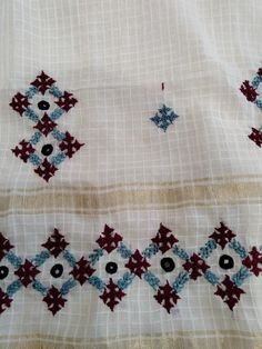 an embroidered cloth with blue, red and white designs on the edges is shown in close up