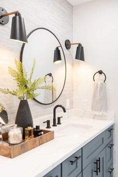 a bathroom with two sinks, mirrors and lights on the wall next to each other